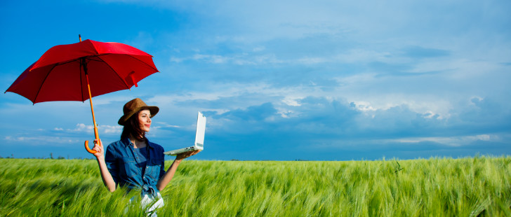 Femme avec un parapluie dans un champ pour l'illustrer l'assurance et le recrutement